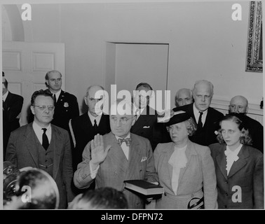 Ein historisches Foto von Präsident Harry S. Truman, der den Amtseid mit Bess und Margaret Truman an seiner Seite ablegte. Dieser Moment ereignete sich nach Franklin D. Roosevelts Tod und markierte Trumans Aufstieg in die Präsidentschaft während des Zweiten Weltkriegs Stockfoto