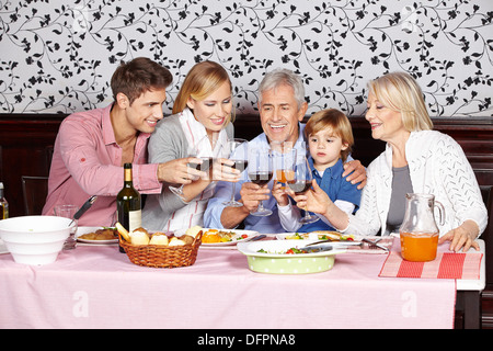 Happy Family im Tisch klirrende Gläser Rotwein Stockfoto