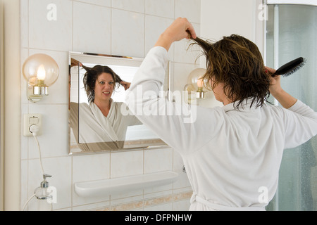 Eine Frau ist Blick in den Spiegel im Bad und ein "bad Hair Day". Stockfoto