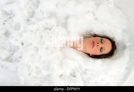 Eine Frau ist mit ihren Augen Cloes ein heißes Bad genießen. Stockfoto