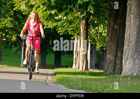 Deutschland, Stuttgart, Rosensteinpark, e-Biken. Frau, Radfahren im Park Stockfoto