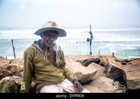 Pol oder Stelzenläufer Fischer in Mirissa-Sri Lanka fangen Fische sitzen auf einem Holzbrett genannt die Petta zu einem vertikalen Pfosten befestigt Stockfoto