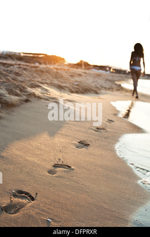 Eine junge Frau zu Fuß auf den Sand. Stockfoto