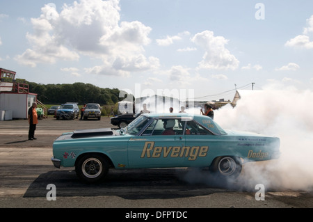 Muscle-Car drehen die Reifen vor einem Drag race Stockfoto