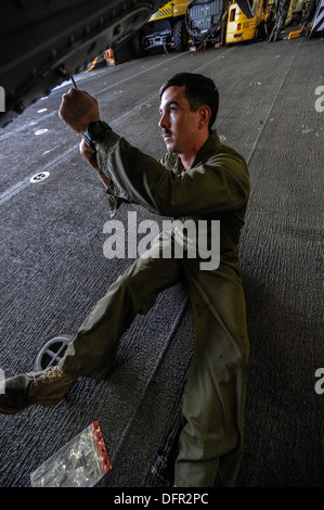 CPL. Eric Holsonback führt Wartungsarbeiten an einem AH-1Z Super Cobra im Hangar Bucht an Bord der amphibischen Angriff Schiff USS Boxer Stockfoto