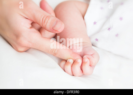 Baby hält die Mutter finger Stockfoto