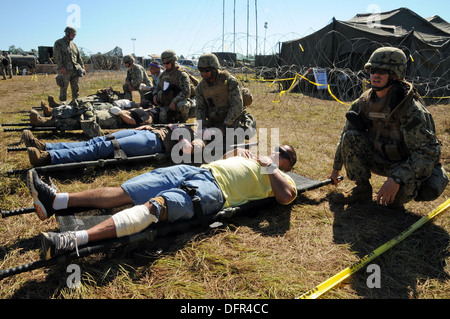 Segler aus Naval Mobile Bau Bataillon (NMCB) 1 behandeln Patienten aus dem fiktiven Land von "East Kojosean" und ihre eigenen Bataillon während einer mass Casualty Drill für NMCB 1 Feld Training Übung (FTX) Betrieb Lager Duell. FTX-Tests der Stockfoto