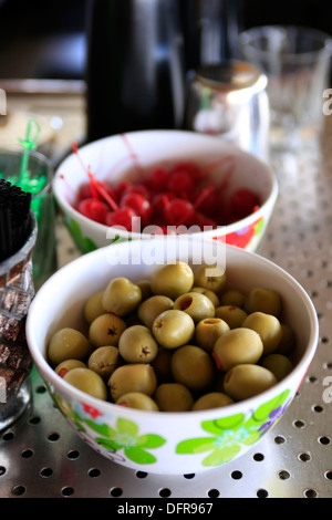 Frischen Oliven und Kirschen in floral Schalen in einer bar Stockfoto