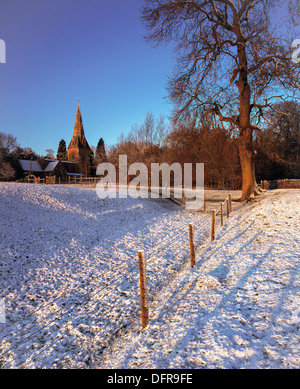 Entfernten Leicestershire Dorfkirche im Winter mit Sonnenaufgang Leuchten Stockfoto