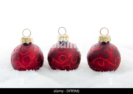 Drei rote Weihnachtskugeln im Schnee Stockfoto