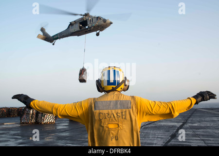 Luftfahrt Boatswain Mate (Handling) 2. Klasse Joseph Foreman leitet einen MH-60 Seahawk Hubschrauber zugewiesen, die staubigen Hunde der Hubschrauber Meer bekämpfen Squadron (HSC) 7 auf dem Flugdeck des Flugzeugträgers USS Harry S. Truman (CVN-75). Harry S. Truma Stockfoto