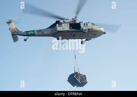 Ein MH-60 Seahawk Hubschrauber zugewiesen, die staubigen Hunde der Hubschrauber Meer bekämpfen Squadron (HSC) 7 liefert Fracht auf dem Flugzeugträger USS Harry S. Truman (CVN-75) während ein Nachschub auf dem Meer. Truman, Harry S. Truman Carrier Flaggschiff Stockfoto