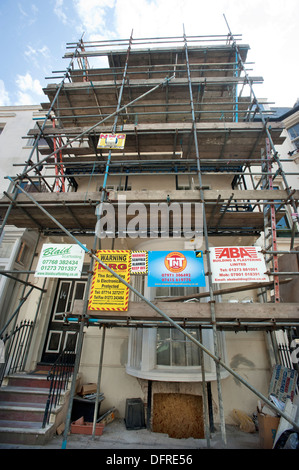 Builders Werbetafeln auf Gerüsten auf eine 1822 gebaut Regency House unter Restaurierung im Zentrum von Brighton. Stockfoto