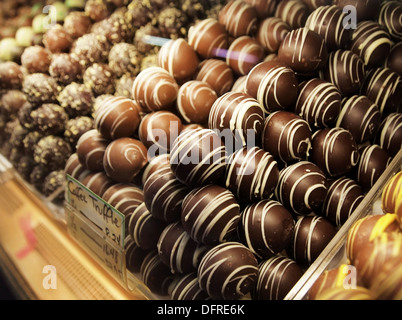 Eine Auswahl an Schokolade Trüffel Bonbons im Glas Vitrine auf einem Markt. Stockfoto