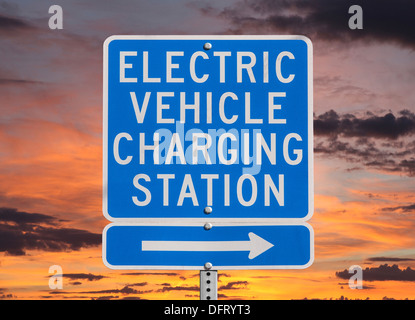 Elektrofahrzeug aufladen Station Zeichen isoliert mit Sonnenuntergang Himmel. Stockfoto
