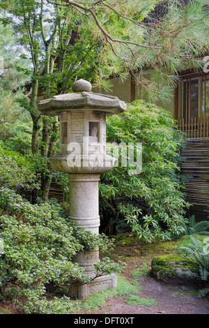 Japanische Stein Laterne im Garten mit Bäume Pflanzen und Sträucher in Herbstsaison Stockfoto