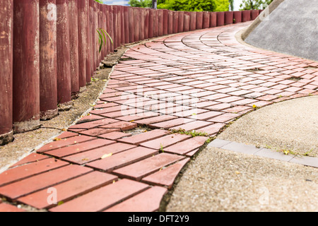 Bürgersteig Schlangenhaft Spaziergang von Pflastersteinen und Holzwänden Garten Stockfoto