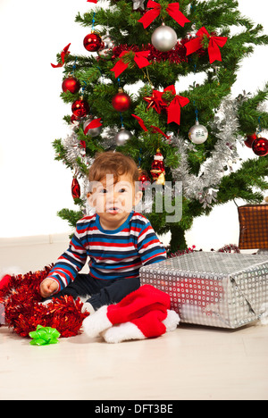 Lustige Baby Boy unter Weihnachtsbaum mit präsentiert Stockfoto