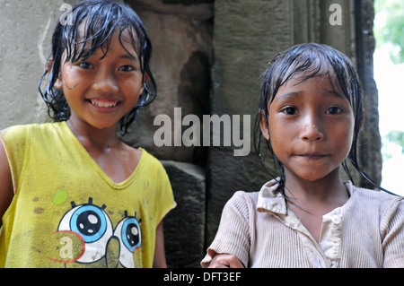 Kambodschanische Mädchen Rest ruht von Wasser in Flaschen zu sammeln, während der Einnahme von Unterschlupf vor dem Regen in Angkor Wat in Siem Reap. Stockfoto