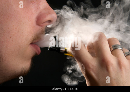 Mann vaping Rauchen eine elektronische e-Zigarette und atme den Rauch Stockfoto