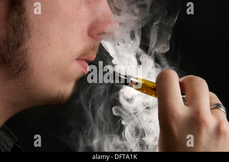 Mann eine elektronische Zigarette rauchen und Ausatmen Dampf Stockfoto