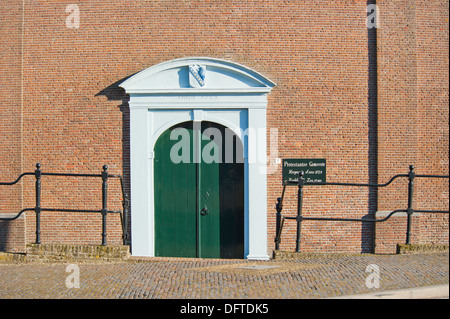 Grüne Eingangstür mit dekorativen weißen Bogen geformt Wandnische der evangelischen Kirche am Altstrecke, Niederlande Stockfoto