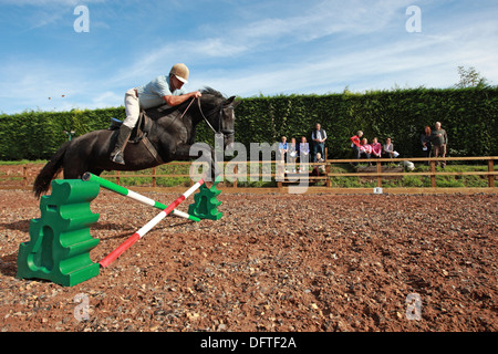 Pferd springen, springt Richard Richardson mit seinem 20 Jahre alten Pferd. Voll Livree stabilen Hof. Forest of Dean, Gloucestershire. VEREINIGTES KÖNIGREICH. Stockfoto