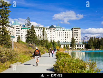 Wanderer zu Fuß rund um den See in Richtung des Fairmont Chateau Lake Louise Hotel Lake Louise, Banff Nationalpark Alberta Kanada Stockfoto