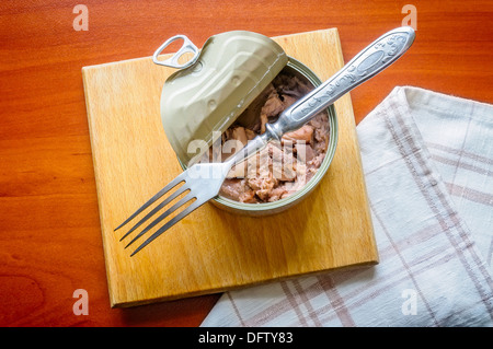 Eine offene Thunfisch-Box auf einem Holzbrett mit einer Gabel und einem Handtuch Stockfoto