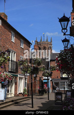 Kakao-Hof, Nantwich, eine Einkaufspassage mit kleinen unabhängigen Steckdosen und einen Blick auf den achteckigen Turm der Marienkirche Stockfoto