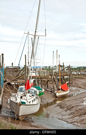 Boote warten auf die Flut in den Schlamm Liegeplätze in Skippool Creek, Fluß Wyre, Lancashire Stockfoto