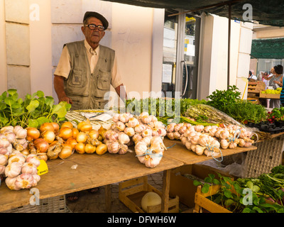 Portugal Algarve Loule Markt Gemüse aus Holz Stall Radieschen Zwiebeln Knoblauch Minze Rosmarin Kräuter salat Anbieter alte Mann grau Beret flacher Deckel hat seinen Höchststand Stockfoto