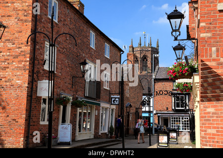 Kakao-Hof, Nantwich, eine Einkaufspassage mit kleinen unabhängigen Steckdosen und einen Blick auf den achteckigen Turm der Marienkirche Stockfoto