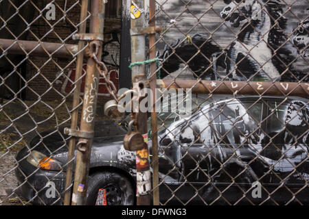 New York City, NY, USA. 9. Oktober 2013. Graffiti-Fans strömen in ein unbebautes Grundstück im Stadtteil Lower East Side von New York auf Mittwoch, 9. Oktober 2013, die neunte Ausgabe von Banksy-Graffiti-Kunst zu sehen. Diese besondere Ausgabe wird durch einen Maschendrahtzaun und einen verschlossenen Zaun angesehen. © Richard Le Credit: Richard Levine/Alamy Live-Nachrichten Stockfoto