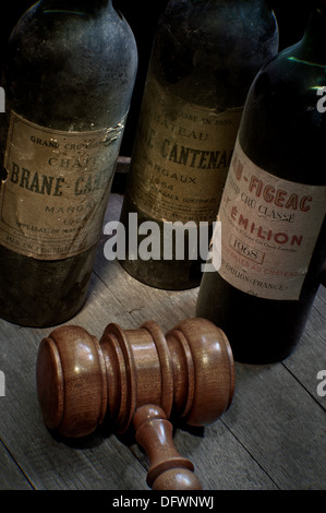 Wein AUKTION französischen Bordeaux Flaschen, Margaux und St. Emilion auf Weinfass mit auktionatoren Hammer im Vordergrund Stockfoto