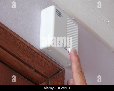 Kaukasischen Mann testen einen Kohlenmonoxid-Monitor-Alarm in häuslicher Umgebung, UK-Modell veröffentlicht Stockfoto