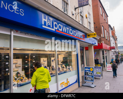 Frau im Fenster H & T Pfandleiher in Nottingham verpfändete Schmuck suchen. Stockfoto