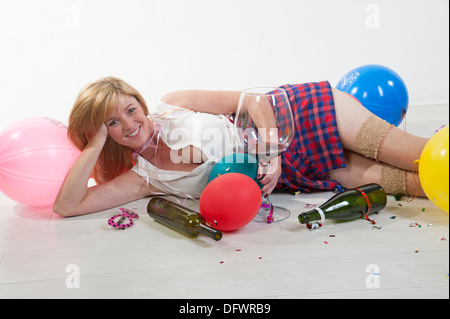 Weibliche Partei-Goer trinken Alkohol aus einem großen Glas Stockfoto