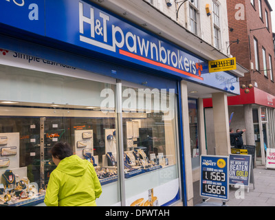 Frau im Fenster H & T Pfandleiher in Nottingham verpfändete Schmuck suchen. Stockfoto