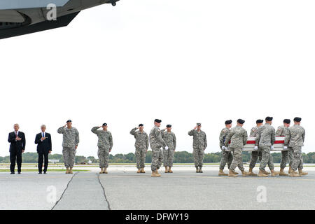 US-Verteidigungsminister Chuck Hagel, links, steht seine Hand über sein Herz mit Secretary Of The Army John McHugh und Army Chief General Ray Odierno und andere militärische Führer wie weiß behandschuhten Soldaten die Fahne drapiert Fall tragen die Reste der Armee Pfc. Cody aus einer c-17 Frachtflugzeug auf der Dover Air Force Base in Dover, DE 9. Oktober 2013 durchgeführt.  Hagel hat angekündigt, dass das Hausfundament Fisher die Familien der gefallenen Soldaten Tod Vorteile bieten wird, die vom Pentagon durch die Regierung Herunterfahren bezahlt werden können. Stockfoto