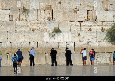 Betende Juden sind neben der Klagemauer in der Altstadt von Jerusalem, Israel, 9. September 2013 abgebildet. Die Klagemauer auf dem Tempelberg der alten Stadt von Jerusalem ist 48 Meter lang und 18 Meter hoch und ist ein wichtiger religiöser Ort des Judentums und einer der am meisten besuchten Orte in Israel. Jeden Tag kommen zahlreiche Menschen an der Klagemauer beten. Viele von ihnen legen Zettel notiert Gebete und Wünsche in die Spalten der Mauer. Orthodoxe Juden ist die Klagemauer ein Symbol für den ewigen Bund Gottes mit seinem Volk. Der Eintritt ist frei. Um auf dem Platz zu erhalten, besuchen Sie Stockfoto