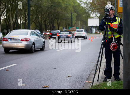 Hamburg, Deutschland. 10. Oktober 2013. Ein Polizist misst die Geschwindigkeit von einem vorbeifahrenden Auto mit einem Laserdetektor Geschwindigkeit in Hamburg, Deutschland, 10. Oktober 2013. Ein 24-Stunden Anstieg der Kontrollen für zu schnelles Fahren ist ganz Deutschland stattfindet. Foto: JAN-PHILIPP STROBEL/Dpa/Alamy Live News Stockfoto