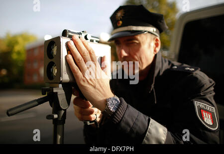 Hamburg, Deutschland. 10. Oktober 2013. Polizeipräsident Hans-Hermann Schulz prüft die Geschwindigkeit von einem vorbeifahrenden Auto mit einem Laserdetektor Geschwindigkeit in Hamburg, Deutschland, 10. Oktober 2013. Ein 24-Stunden Anstieg der Kontrollen für zu schnelles Fahren ist ganz Deutschland stattfindet. Foto: AXEL HEIMKEN/Dpa/Alamy Live News Stockfoto
