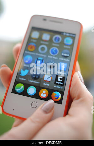 München, Deutschland. 10. Oktober 2013. Eine Frau hält eine Smartphone mit dem Betriebssystem Firefox während einer Pressekonferenz von Telekom Tochter Congstar in München, Deutschland, 10. Oktober 2013. Congstar ist der erste, der das Smartphone in Deutschland mit dem Betriebssystem der open-Source-Spezialisten bieten. Foto: ANDREAS GEBERT/Dpa/Alamy Live-Nachrichten Stockfoto