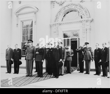 Präsident Harry S. Truman und Prinz Charles von Belgien sowie andere Würdenträger stehen während einer formellen diplomatischen Veranstaltung am Eingang des Weißen Hauses zur Aufmerksamkeit. Stockfoto