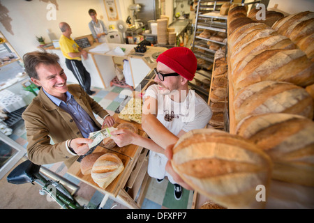 Funktion auf dem Bristol-Pfund - The East Bristol Bakery, Inhaber und Leiter Baker Alex Poulter dient ein Kunde Aug 2013 Stockfoto