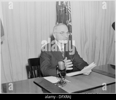 Ein Foto von Präsident Harry S. Truman, der eine Radioansprache an die Nation über das Umkehrprogramm nach dem Zweiten Weltkrieg hält, das sich auf den Übergang von der Kriegszeit zur Friedenswirtschaft konzentriert. Stockfoto