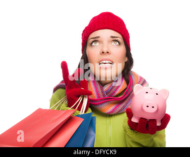 Betonte Mischlinge Trägerin Winterkleidung nachschlagen mit Einkaufstüten und Sparschwein, Isolated on White Background. Stockfoto
