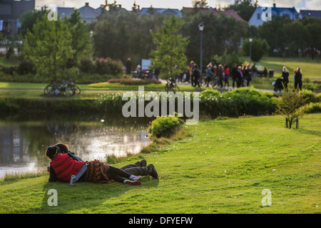 Paar genießt einen schönen Sommertag im Park, Reykjavik, Island Stockfoto