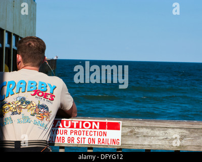 Mann trägt Crabby Joe-T-Shirt auf dem Pier in Daytona Beach shores Stockfoto